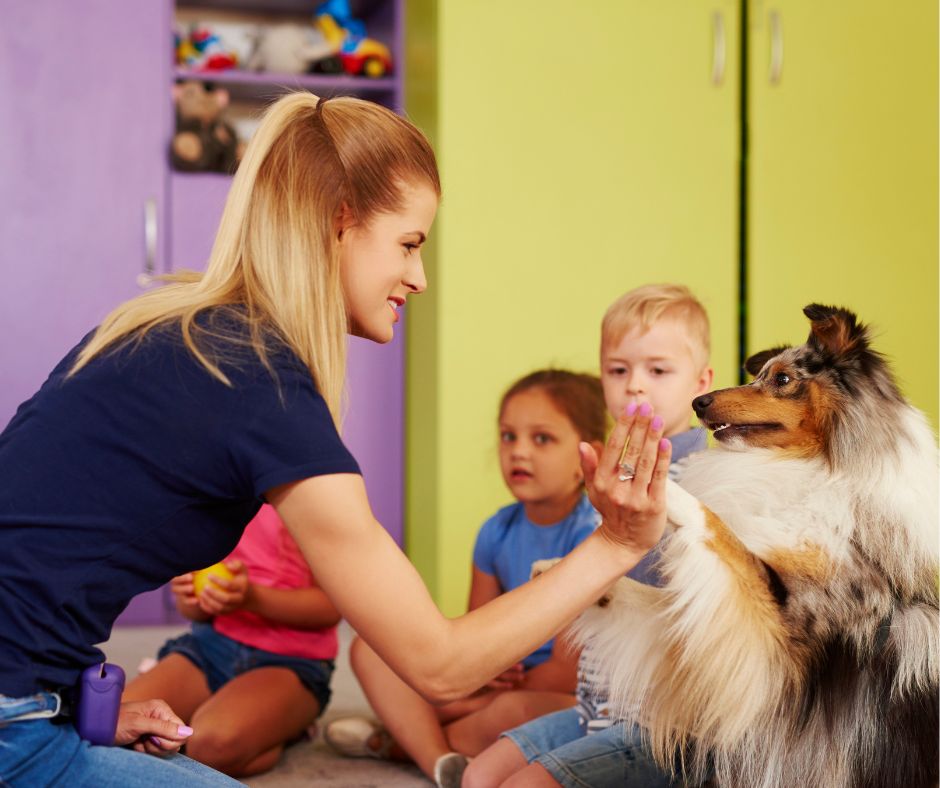 dogoterapeuta przybija piątkę z psem pracującym w przedszkolu